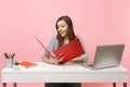 Amazed woman looking on red folder with paper work documents working on project while sitting at office with laptop Royalty Free Stock Photo