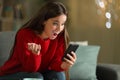 Amazed woman reading news on phone in the night