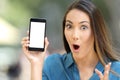 Amazed woman showing a blank smart phone screen