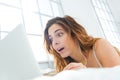 Amazed woman using laptop computer on the bed Royalty Free Stock Photo
