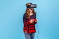 Woman in vr headset, playing virtual reality game with joypad, has excited smile on her face.