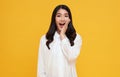 Amazed young Asian teen woman looking at camera on yellow background Royalty Free Stock Photo