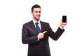 Amazed young businessman holding and pointing on blank screen smartphone over white Royalty Free Stock Photo