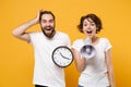 Amazed young couple friends bearded guy girl in white blank empty t-shirts isolated on yellow orange wall background in Royalty Free Stock Photo
