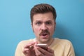 Amazed young guy reads a message on the phone. Royalty Free Stock Photo