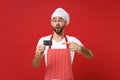 Amazed young male chef cook or baker man in striped apron white t-shirt toque chefs hat isolated on red background Royalty Free Stock Photo