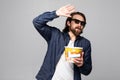 Amazed young man eating popcorn with 3d glasses isolated on a white background Royalty Free Stock Photo