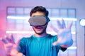 Amazed Young man first time experiencing vr or virtual reality headset on neon light background - concept of futuristic Royalty Free Stock Photo