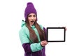 Amazed young pretty woman in purple ski coat show empty tablet Royalty Free Stock Photo