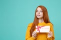 Amazed young redhead woman girl in yellow knitted sweater posing isolated on blue turquoise background in studio. People Royalty Free Stock Photo