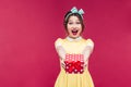 Amazed young woman holding and giving present box to you Royalty Free Stock Photo