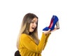 Amazed young woman holding a pair of high heel shoes over white background Royalty Free Stock Photo