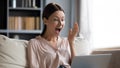 Amazed young woman looking at laptop screen, resting on sofa. Royalty Free Stock Photo