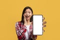 Amazing ad. Excited asian woman holding smartphone with blank screen in hand, showing space for app or website, mockup Royalty Free Stock Photo