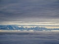 Amazing aerial view of misty swiss alps and clouds above the mountain peaks from airplane Royalty Free Stock Photo