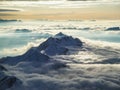 Amazing aerial view of misty swiss alps and clouds above the mountain peaks from airplane Royalty Free Stock Photo