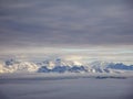 Amazing aerial view of misty swiss alps and clouds above the mountain peaks from airplane Royalty Free Stock Photo