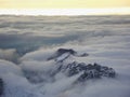 Amazing aerial view of misty swiss alps and clouds above the mountain peaks from airplane Royalty Free Stock Photo