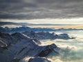 Amazing aerial view of misty swiss alps and clouds above the mountain peaks from airplane Royalty Free Stock Photo