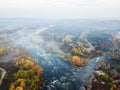 Amazing aerial view of mountain rocks, blue foggy river and colorful forest on sunrise. autumn landscape Royalty Free Stock Photo