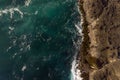 Amazing aerial view of ocean waves hitting rocks. Fantastic blue water mix with gray rocks. Idea for wallpaper Royalty Free Stock Photo