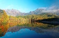 Amazing autumn lake scenery of Kagami Ike Mirror Pond in morning light with symmetric reflections of colorful fall foliage Royalty Free Stock Photo