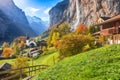 Amazing autumn landscape of touristic alpine village Lauterbrunnen with famous church and Staubbach waterfall Royalty Free Stock Photo