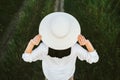 Amazing background. Portrait of beautiful and adorable, charming back view of young pretty brunette woman with hands on a hat, on Royalty Free Stock Photo