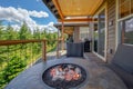 Amazing balcony patio with fire pit and forest and mountains view. Dream come true home exterior. New AMerican architecture. Royalty Free Stock Photo