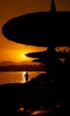 Amazing beautiful red sunset on the sea coast. Dark silhouettes of beach umbrellas Royalty Free Stock Photo