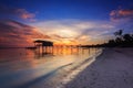 Amazing beautiful sunset with silhouette wooden jetty and coconut tree