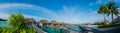 Amazing beautiful tropical beach panorama of water bungalos with bridge near the ocean and palm trees at Maldives