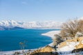 Amazing beautiful winter landscape of Charvak reservoir in Uzbekistan in winter with blue water in it, surrounded by the Tien Shan Royalty Free Stock Photo