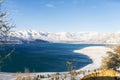 Amazing beautiful winter landscape of Charvak reservoir in Uzbekistan in winter with blue water in it, surrounded by the Tien Shan Royalty Free Stock Photo