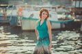 Amazing beautifull lady girl woman with red flame hair wearing fancy fashion green clothes posing sitting on wooden pier jetty wth