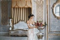 Amazing beauty, busty brunette, model girl in a wedding lace dress posing in interior Royalty Free Stock Photo