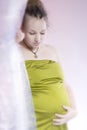 Amazing beauty pregnant woman behind curtain