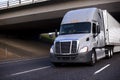Amazing big rig grey semi truck with semi trailer driving under Royalty Free Stock Photo