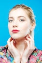 Amazing Blonde with Sensual Lips and Perfect Skin Wearing Colorful Shirt on Blue Background in Studio. Body Care Concept