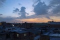 Amazing blue and orange dusk with cloudy sky at industrial neighborhood with city lights