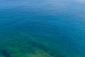 Amazing blue sea with sparkling highlights and green algae off the coast. Background of sea water