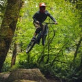 Extreme Sports Athlete Catching Air on Forest Mountain Bike Jumps