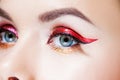 Amazing Bright eye makeup in luxurious red arrow. Red and gold shining tones, eye shadow.
