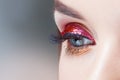 Amazing Bright eye makeup in luxurious red arrow. Red and gold shining tones, eye shadow.