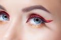 Amazing Bright eye makeup in luxurious red arrow. Red and gold shining tones, eye shadow.