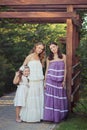 Amazing Brunette blond chestnut blue eyes sisters girls wearing stylish white purple dress enjoying vacation together spring sunny