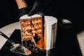 Amazing Cakes. A black-gloved chef is slicing a chocolate wedding cake. The wedding Cake is delicious inside on a black background Royalty Free Stock Photo