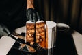 Amazing Cakes. A black-gloved chef is slicing a chocolate wedding cake. The wedding Cake is delicious inside on a black background Royalty Free Stock Photo