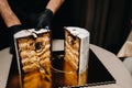 Amazing Cakes. A black-gloved chef is slicing a chocolate wedding cake. The wedding Cake is delicious inside on a black background Royalty Free Stock Photo