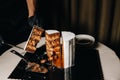 Amazing Cakes. A black-gloved chef is slicing a chocolate wedding cake. The wedding Cake is delicious inside on a black Royalty Free Stock Photo